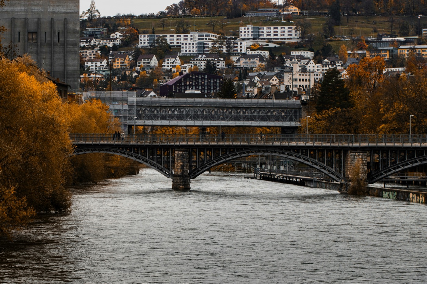 Eine Brücke über einen Fluss im Herbstlicht — Sinnbild für Verbindung zwischen zwei Welten